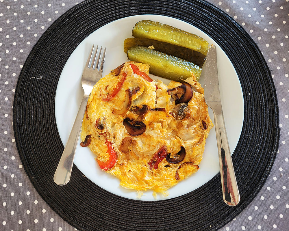 Omelett med paprika, gul lök och champinjoner. Inlagd gurka.