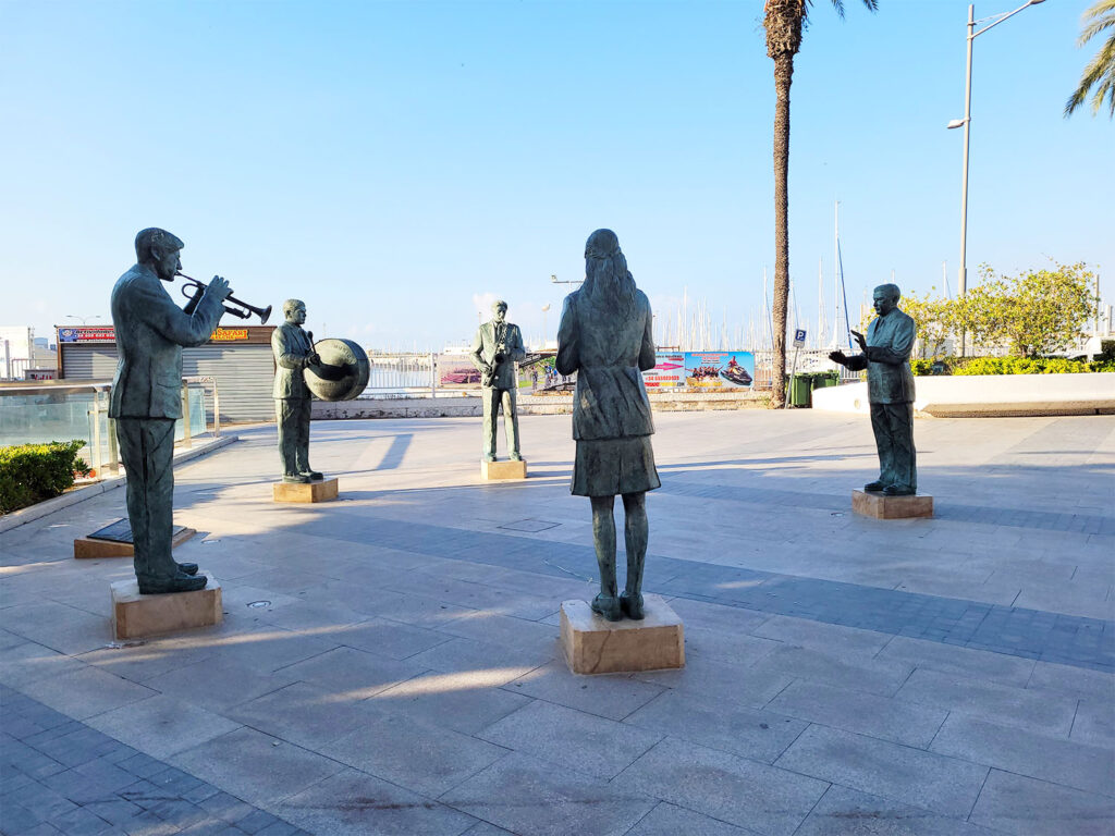 Staty av fem musiker som står i en ring och spelar instrument.