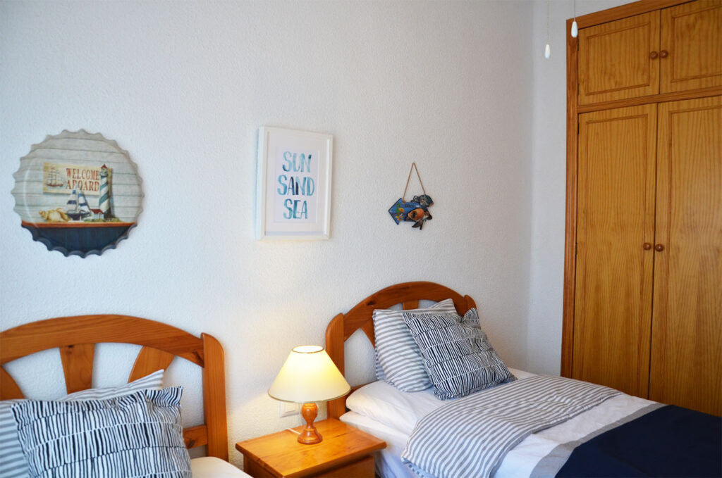 Sovrum med två sängar och tavlor på väggen.