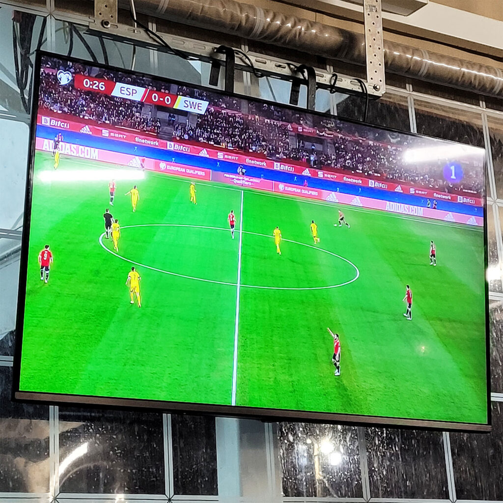 Storbilds-tv som visar en fotbollsmatch.