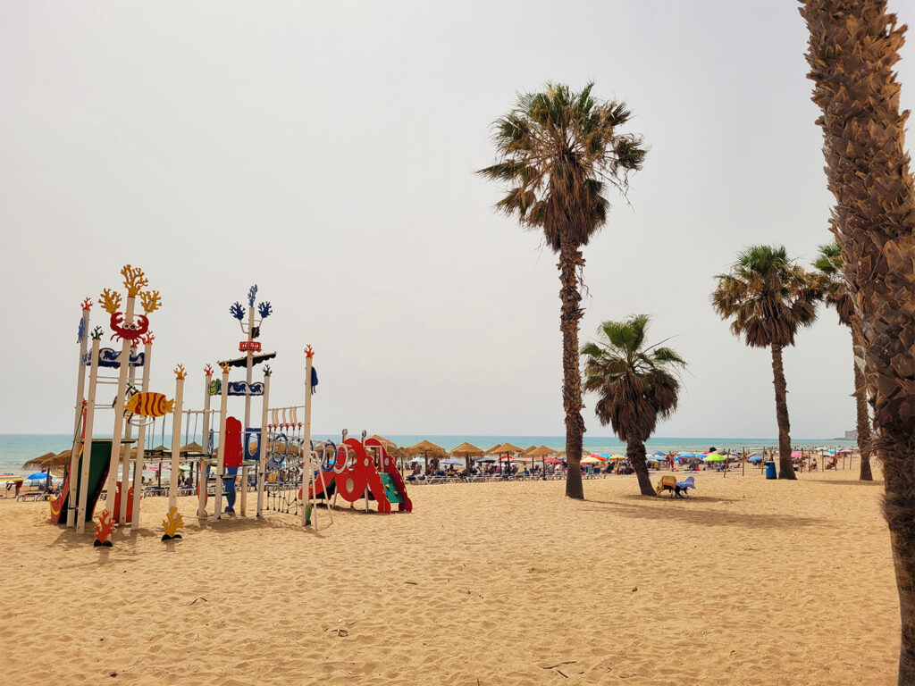 Lekplats och palmer på stranden.